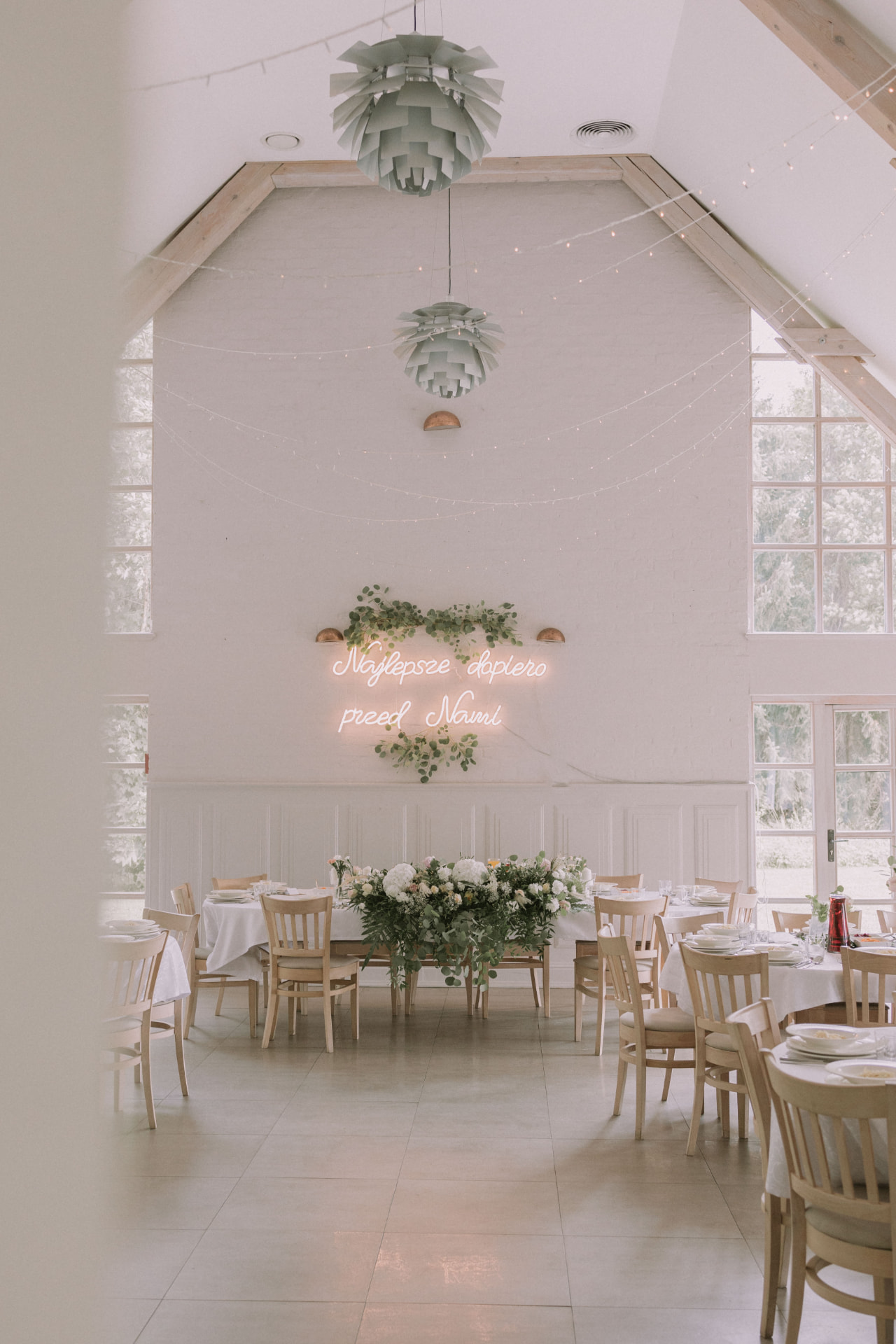 Elegancka sala weselna z neonem i kwiatową dekoracją